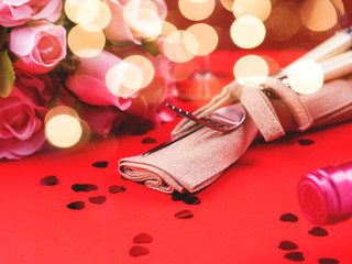 Festive woman, valentine day dinner concept on red background with heart confetti, rose flowers, envelope and elegant silverware on napkin.