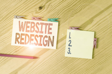 Wall Mural - Writing note showing Website Redesign. Business concept for modernize improver or evamp your website look and feel Colored clothespin papers empty reminder wooden floor background office