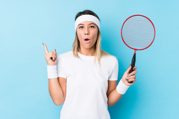 Young caucasian woman playing badminton isolated having some great idea, concept of creativity.