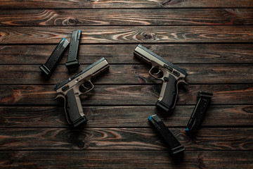 Wall Mural - Modern brown guns on a wooden background. Pistol. Weapons for sport and self-defense lie on the table.