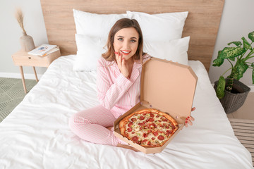 Wall Mural - Morning of beautiful young woman with tasty pizza in bedroom