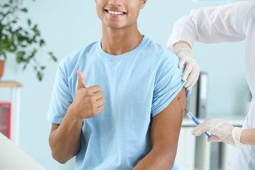 Wall Mural - Doctor vaccinating teenage boy in clinic