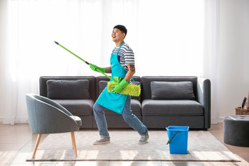 Canvas Print - Young Asian man having fun while doing chores at home