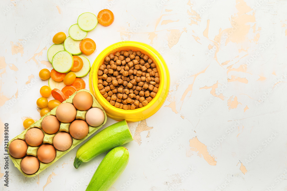 Composition with dry pet food and natural products on light background