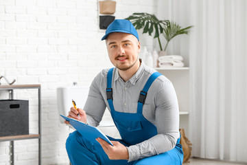 Wall Mural - Portrait of handsome plumber in bathroom