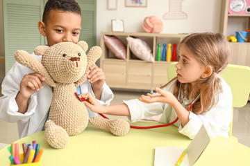 Sticker - Cute little children dressed as doctors playing at home