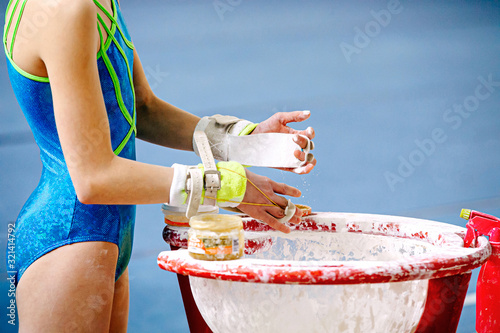 Cuadros en Lienzo girl gymnast in gymnastics hand grips smearing gym chalk