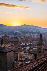 Canvas Print - Sunset in Bologna, aerial view of rooftops and hill with San Luca Monastery.