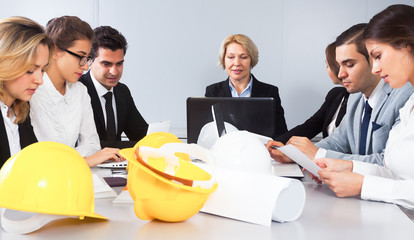 Wall Mural - Mature blonde woman leads meeting of architects