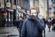 © Viesturs - Handsome young European man in winter clothes on the street with a medical face mask on. Closeup of a 35-year-old male in a respirator to protect against infection with influenza virus or coronavirus
