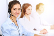 © rogerphoto - Call center. Focus on beautiful business woman using headset in sunny office
