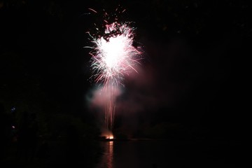 fireworks exploding in the skies, reflections in the water