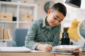 Cute little boy doing homework. Child learning foe school.