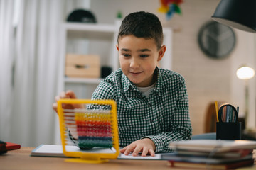 Cute little boy doing homework. Child learning foe school.