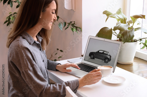 Fotografía Woman using laptop to buy car at table indoors