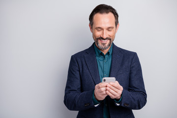 Poster - Photo of handsome business man holding telephone hands reading corporate good news email toothy smile formalwear blazer shirt blue plaid suit isolated grey color background