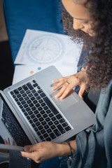 caucasian female astrologer looking at her laptop