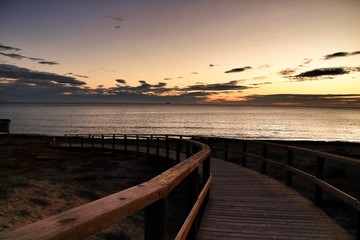  Wooden walkway to the beach at sunrise in Alicante, Spain