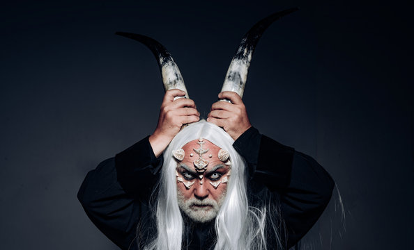 Tree spirit and fantasy concept. Man wizard with fantastic make up on demon face. Magic and fairy tale concept. Man evil with horns. Viking with a horned head. Devil horns. Man with a bull head.