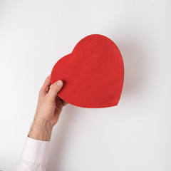 Wall Mural - Vintage style red heart shaped box in male hand isolated on white background