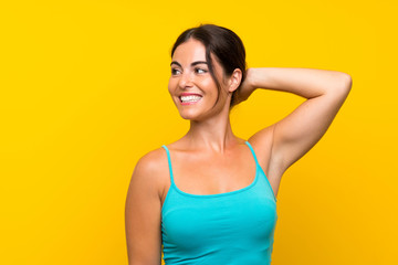 Wall Mural - Young woman over isolated yellow background laughing