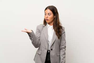 Wall Mural - Young business woman over isolated white background holding copyspace imaginary on the palm