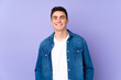 © luismolinero - Teenager caucasian  handsome man isolated on purple background laughing