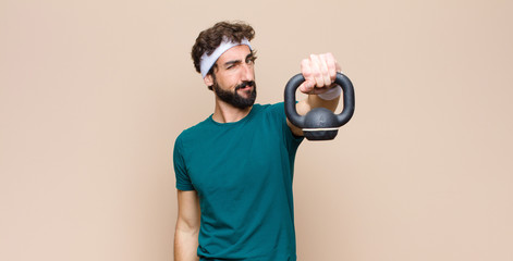 Wall Mural - young cool bearded man at gym with a dumbbell. sport concept