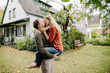 © Westend61 - Happy couple kissing in garden, in front of their dream house