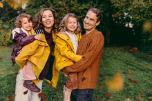 Portrait Of Happy Family With Two Daughters Outdoors In Autumn