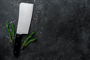 meat ax, kitchen knife with  spices on stone background, with copy space