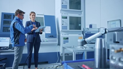 Poster - Modern Factory: Female Project Manager and Male Engineer Standing, Talking and Using Tablet Computer for Programming Robot Arm Assembly Line. Industry 4.0 Facility with High Tech CNC Machinery