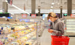 Teenager shopping in supermarket, reading product information 