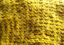 Texture And Background Of Yellow Yarn Knitted Fabric. Warm And Cozy Knitted Jacket.