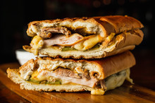 Traditional Cuban Sandwich With Cheese, Ham And Fried Pork, Served On A Wooden Board