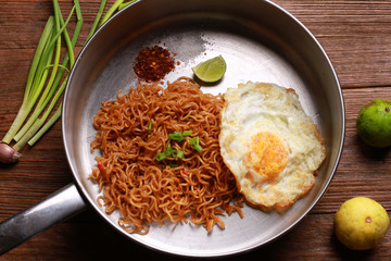 Wall Mural - Mi goreng or mee goreng mamak, Indonesian and Malaysian cuisine, spicy fried noodles on wooden table.