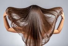 Back View Of A Brunette Woman With A Long Straight Hair.