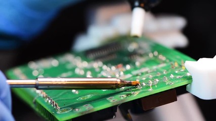 Wall Mural - Technical support worker drops the fee PCB. Soldering iron