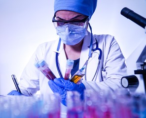 female lab technician doing research with a microscope in the lab.