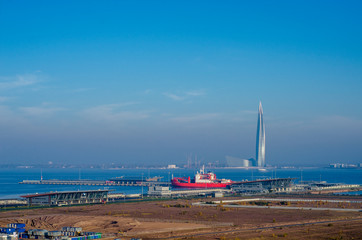 Bright sunny panorama of the city in the early morning. Coastal sea panorama of the city with blue sky. Newly formed island territory of the city. Technology of alluvial territory. 