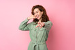 © luismolinero - Young pretty woman over isolated pink background making phone gesture and pointing front