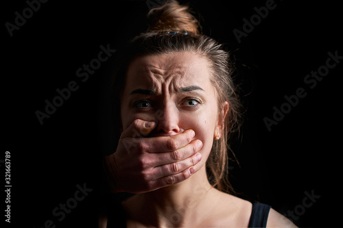 Cuadros en Lienzo Stressed unhappy scared crying woman victim in fear with closed mouth on a dark