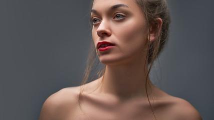 Beauty portrait of young attractive sensual caucasian brunette female model with shiny clean skin, red lips and bare shoulders. Natural beauty and beautiful woman