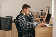 © Alena Ozerova - Teenage boy doing homework using computer sitting by desk in room alone