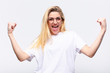 © kues1 - young pretty blonde woman feeling happy, surprised and proud, shouting and celebrating success with a big smile against white wall