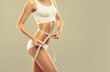© Sofia Zhuravetc - Perfect slim toned young body of the girl . An example of sports , fitness or plastic surgery and aesthetic cosmetology.Woman measuring her waist over white background