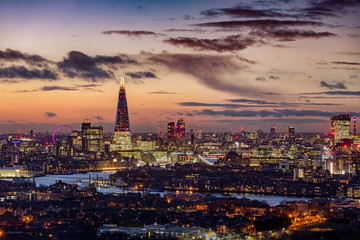 Fototapete - Die markante Skyline von London am Abend mit den beleuchteten Hochhäusern entlang der Themse und zahlreichen Sehenswürdigkeiten, Großbritannien