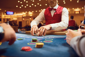 Gambling in a casino. The croupier holds poker cards in a casino.