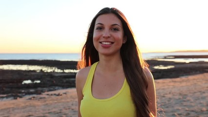 Wall Mural - Portrait of beautiful young woman laughing cheerful enjoying lifestyle looking at camera on calm beach sunset feminine beauty. Slow motion.