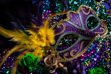 Colorful Mardi Gras Mask On Purple Background With Beads